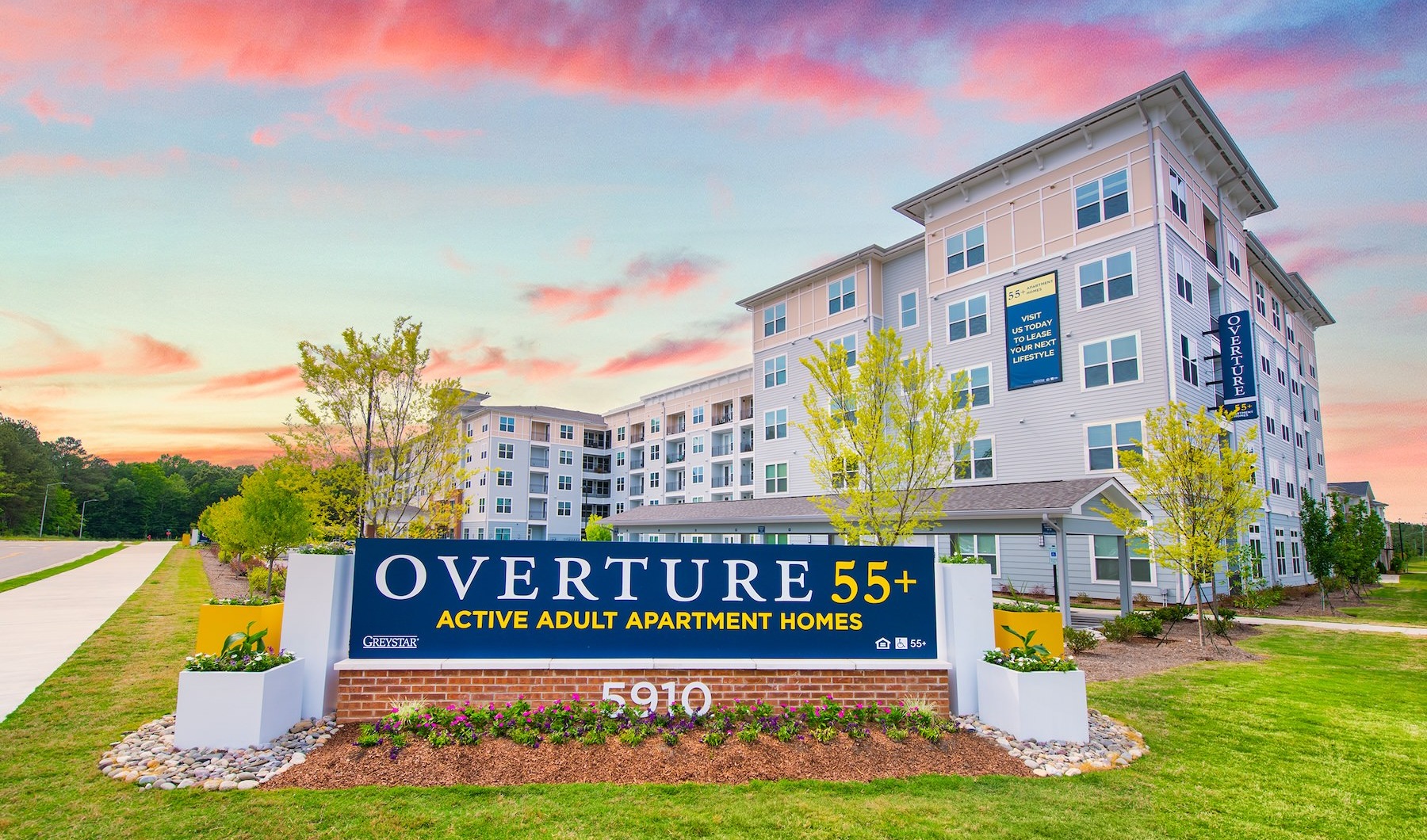 The exterior of Overture Chapel Hill senior living apartments in Chapel Hill, NC featuring a modern facade and entrance sign.