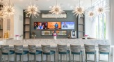 well lit lounge with bar seating and a tv