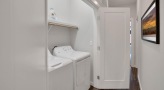 side-by-side washer/dryer units in laundry closet with light