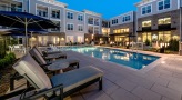a swimming pool with lounge chairs and umbrellas next to it