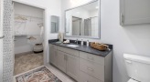 a bathroom with a large mirror and walk-in closet