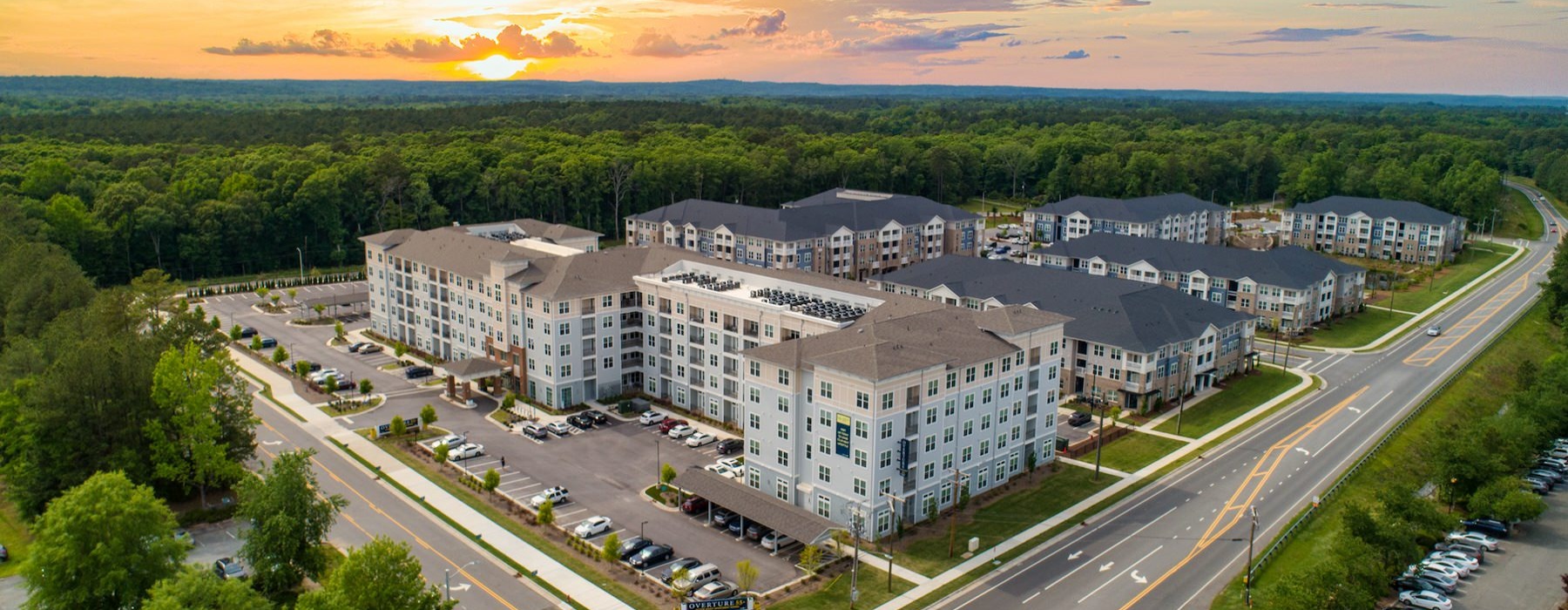 Aerial view of Overture Chapel Hill senior living apartments in Chapel Hill, NC featuring the sunset and apartment exteriors.
