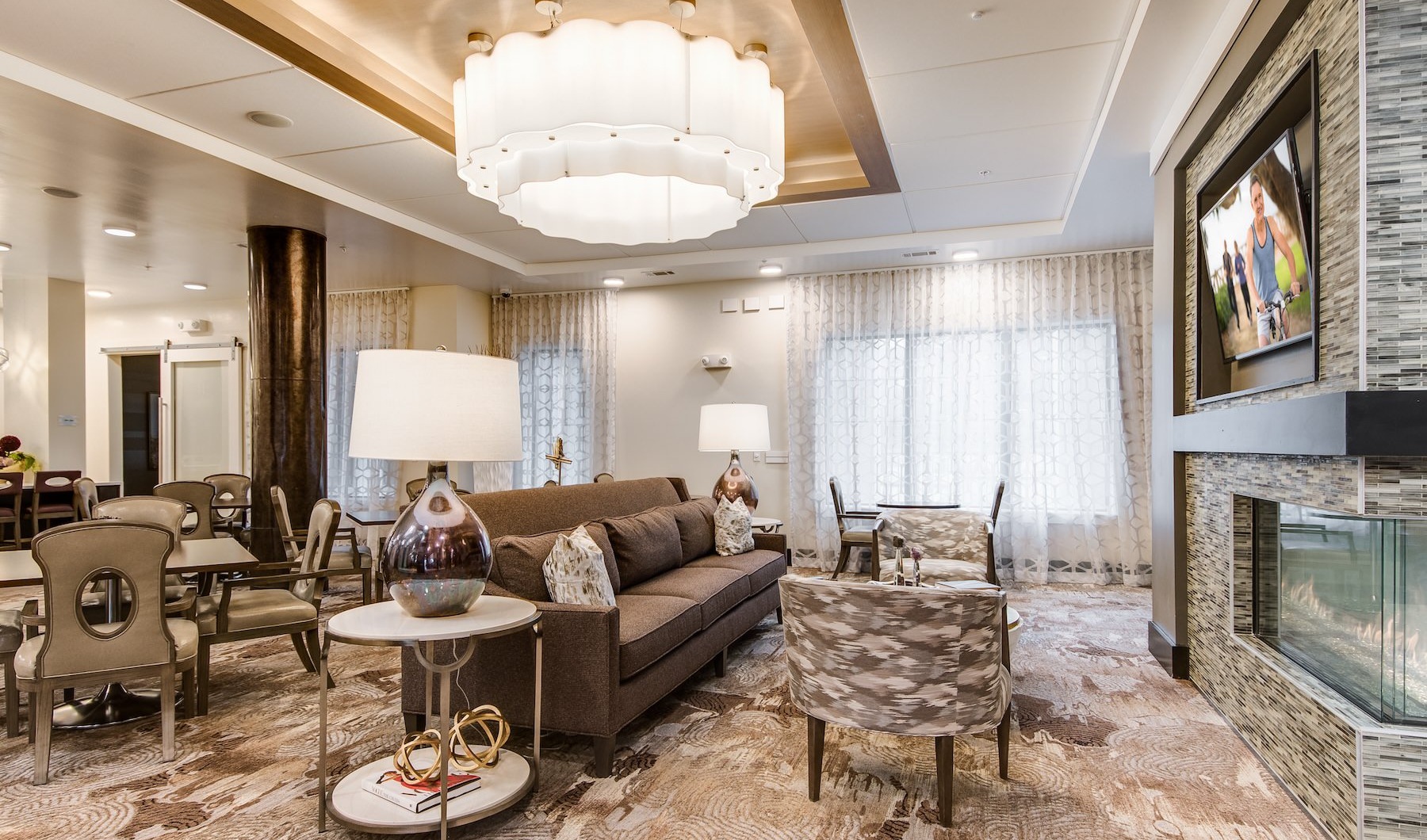 Resident lounge at Overture Stone Oak apartments in San Antonio, TX, featuring couches, and modern lighting fixtures.
