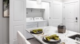 Spacious and well lit kitchen with stainless steel appliances and dark accents 