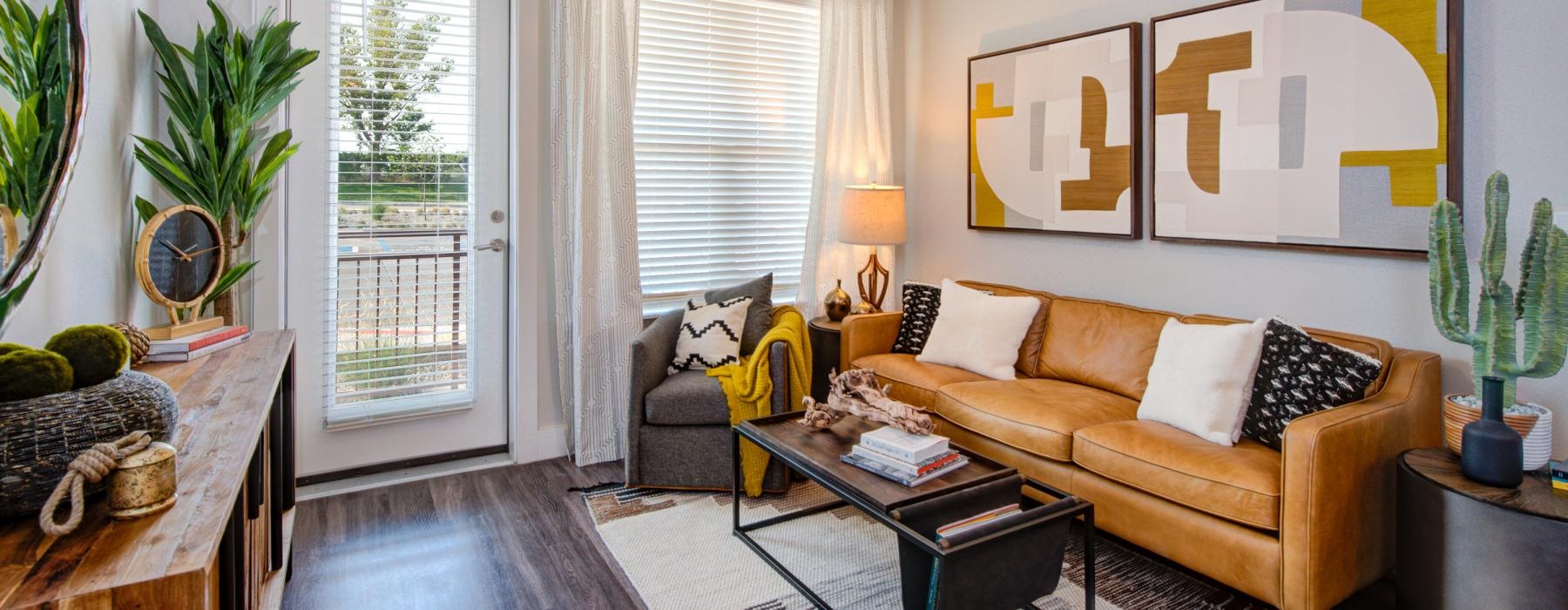 Model living room at Overture Albuquerque 55 and over apartments in Albuquerque, NM, featuring wood grain floor paneling.