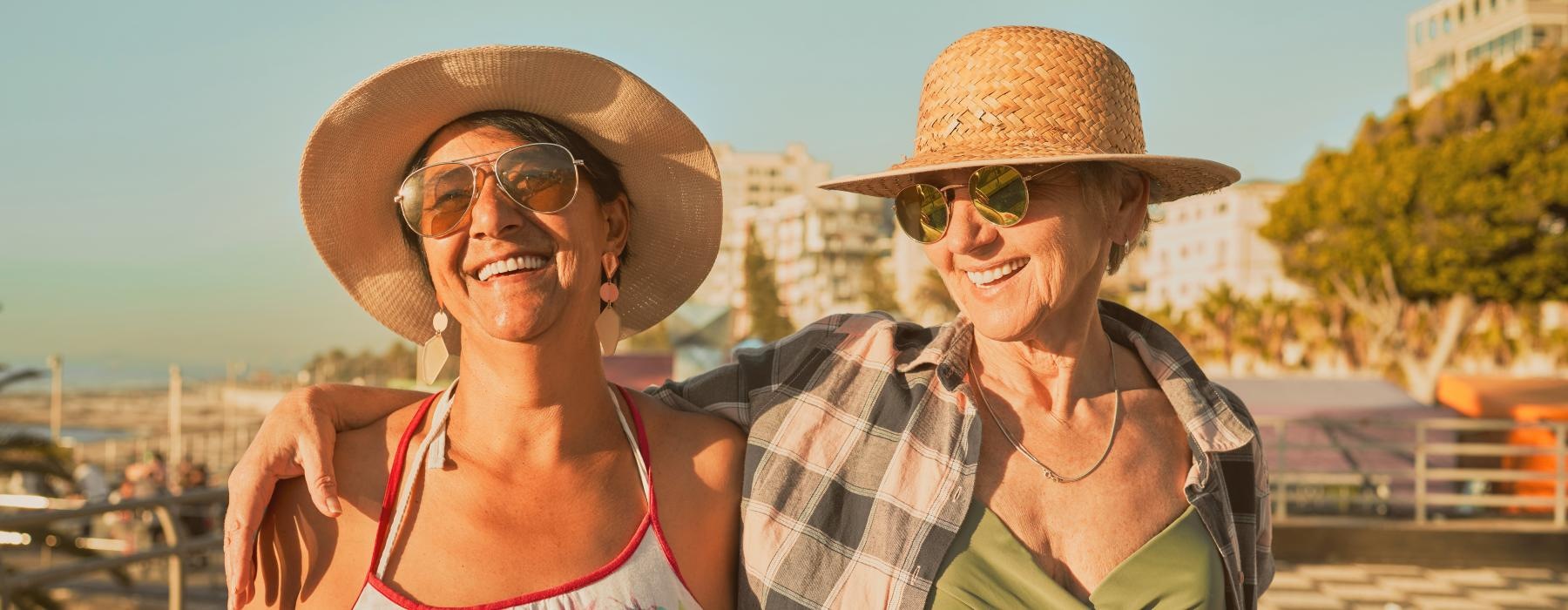 Two residents smiling and hugging in the sun at Overture San Marcos over 55 apartments in San Marcos, CA.