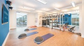 Large yoga room with wood floors and large mirrors 