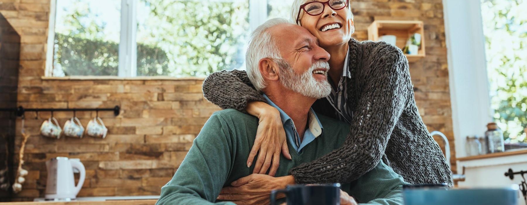 Residents hugging and smiling at Overture Yorktown 55 and older apartments in Lombard, IL, featuring natural lighting.