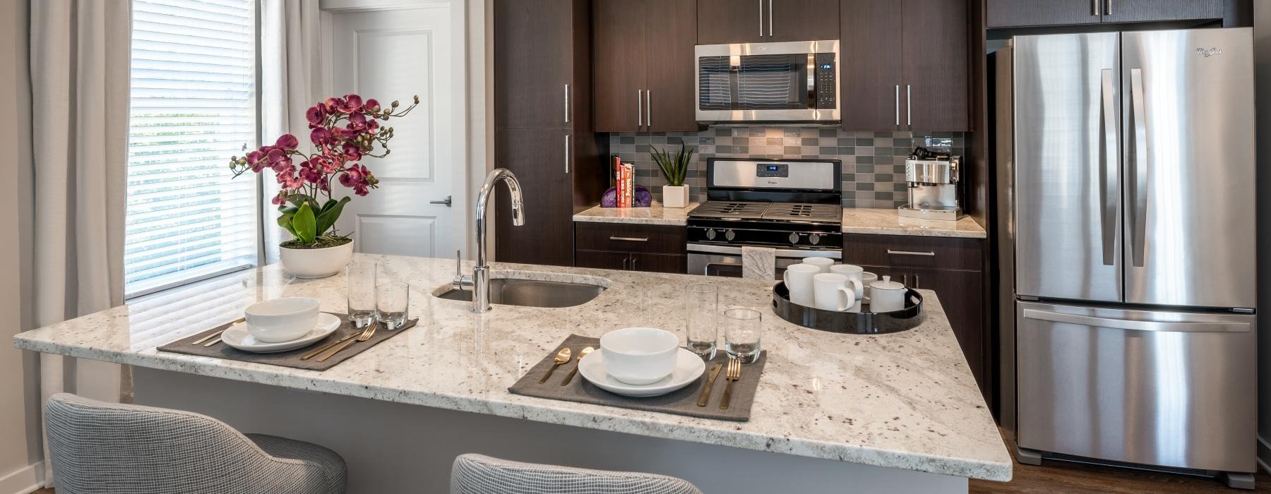 Model kitchen at Overture Fair Ridge senior living apartments in Fairfax, VA, featuring stainless steel appliances.