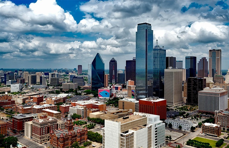 a cityscape with blue skies and clouds