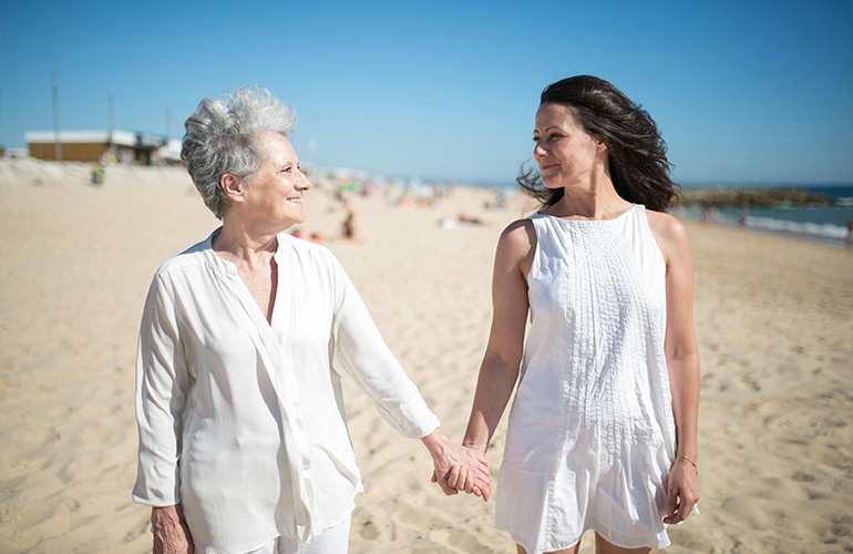 two women walking on a beach