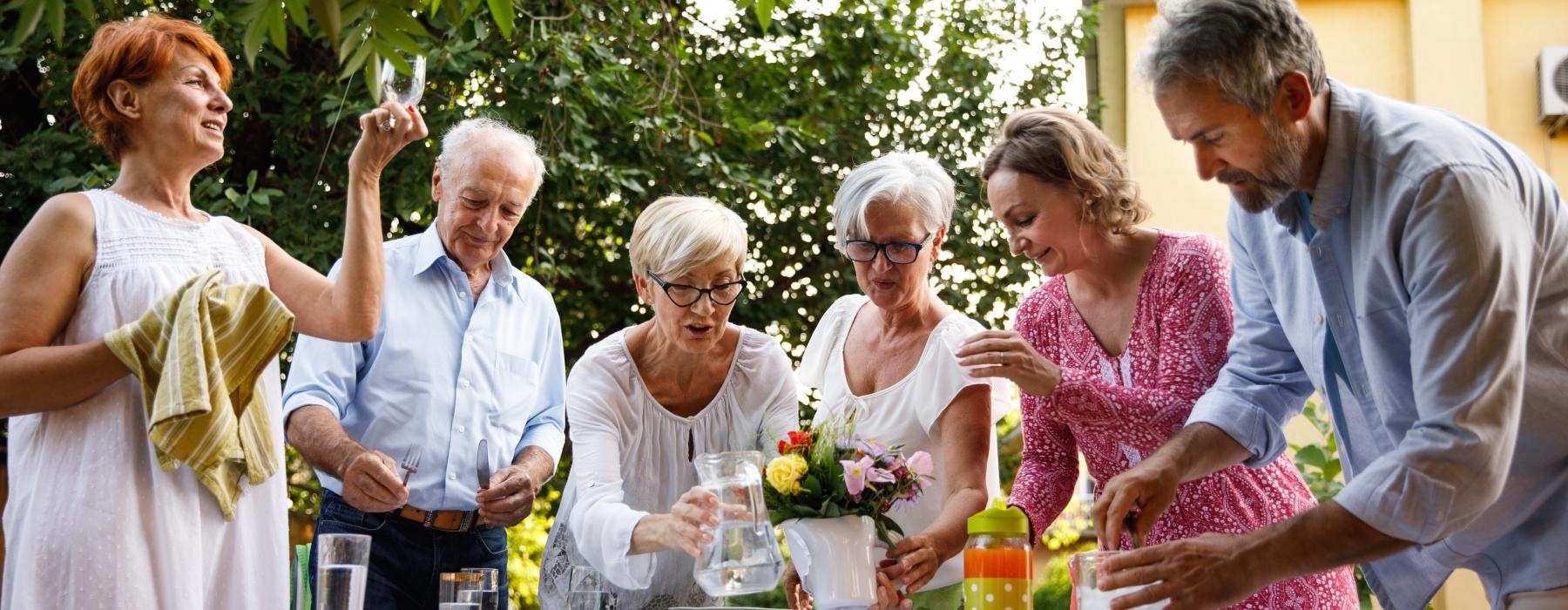 Residents standing outside with glasses of water at Overture Plano senior living apartments in Plano, TX.