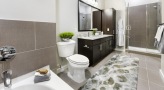 Large well lit bathroom with white accents 