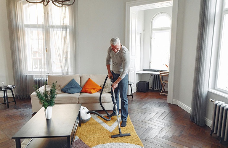 a man vacuuming a carpet
