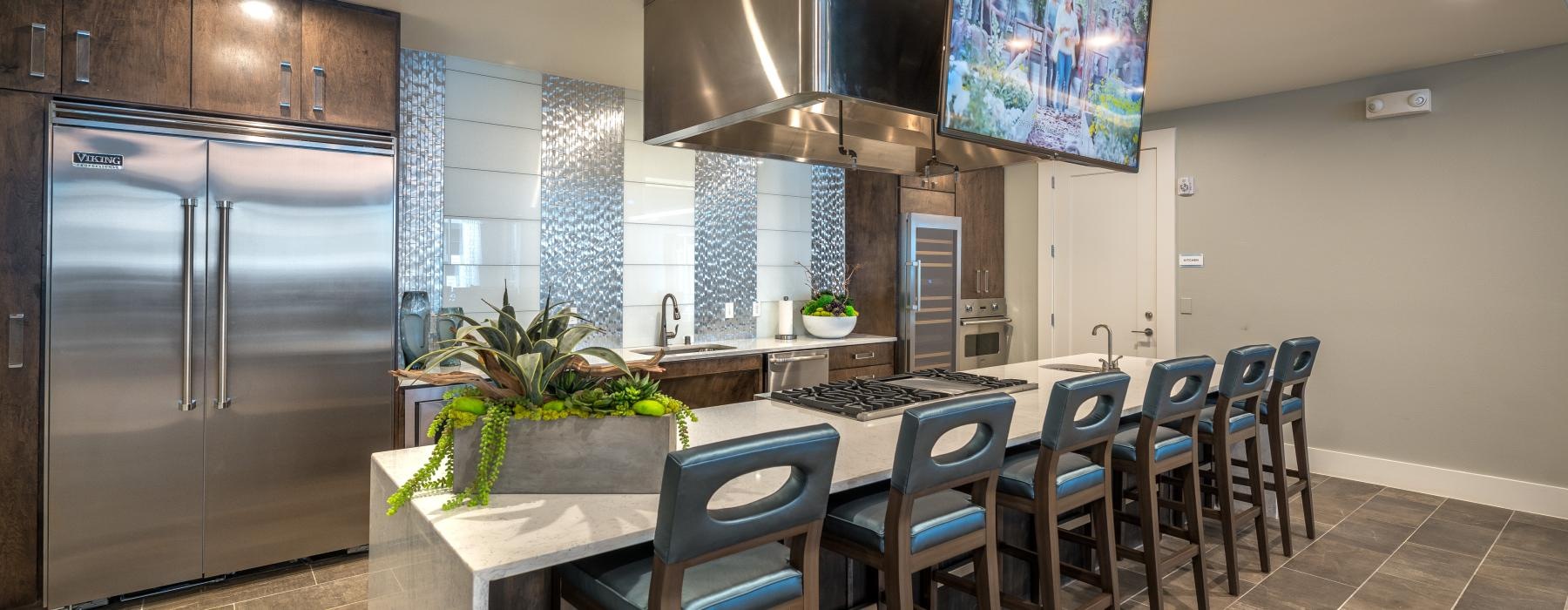 Resident lounge at Overture Plano senior living apartments in Plano, TX, featuring counter seating and a flat screen TV.