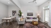 Spacious and well lit living room with wood floors and a large window