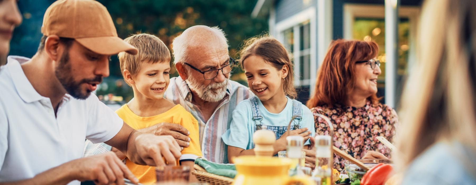 Family and friends sharing a summertime meal outdoors at Overture Dr. Phillips apartments in Orlando, FL.