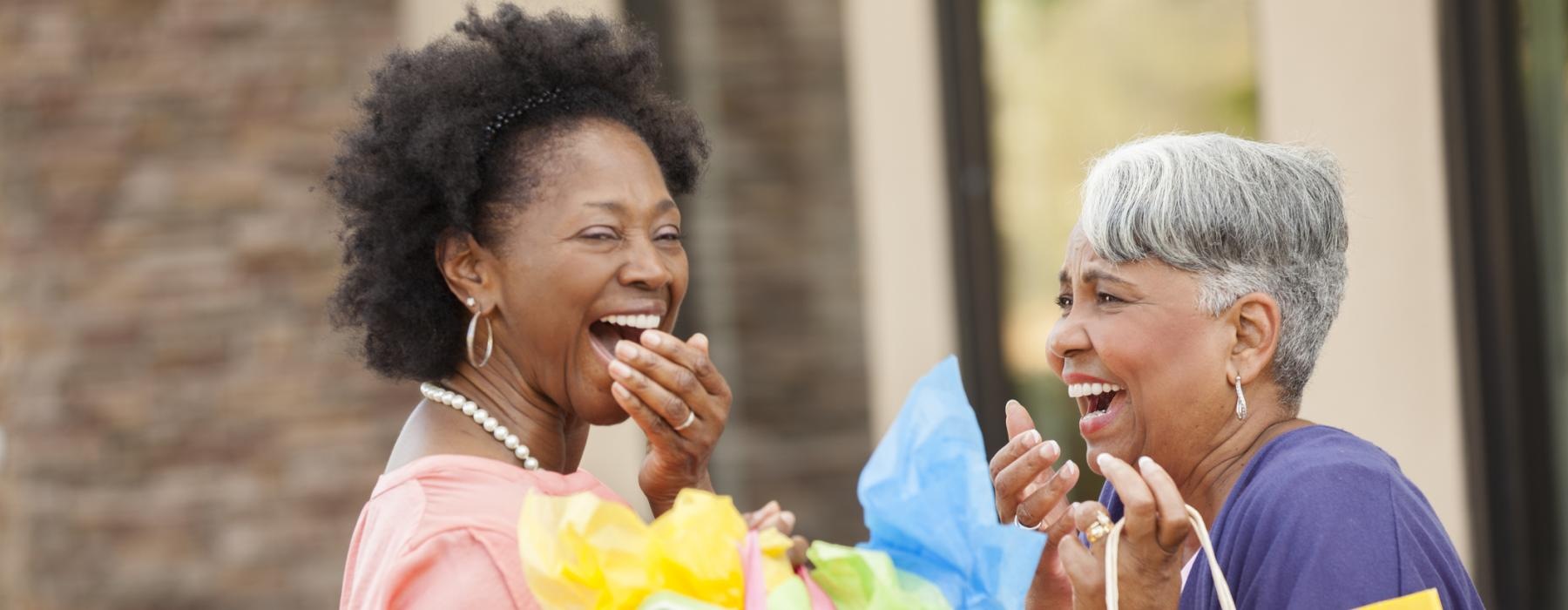 two women holding bag laughing