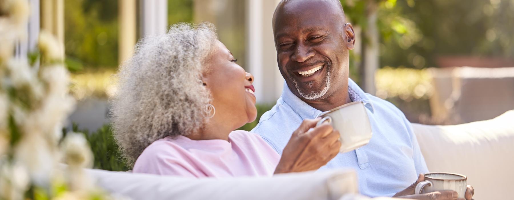 Residents sitting outside with cups of coffee at Overture West Ashley senior living apartments in Charleston, SC.