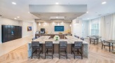 Large clubroom with wood floors and ample seating 