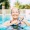 A resident smiling and swimming in the outdoor swimming pool at Overture Dr. Phillips apartments in Orlando, FL.