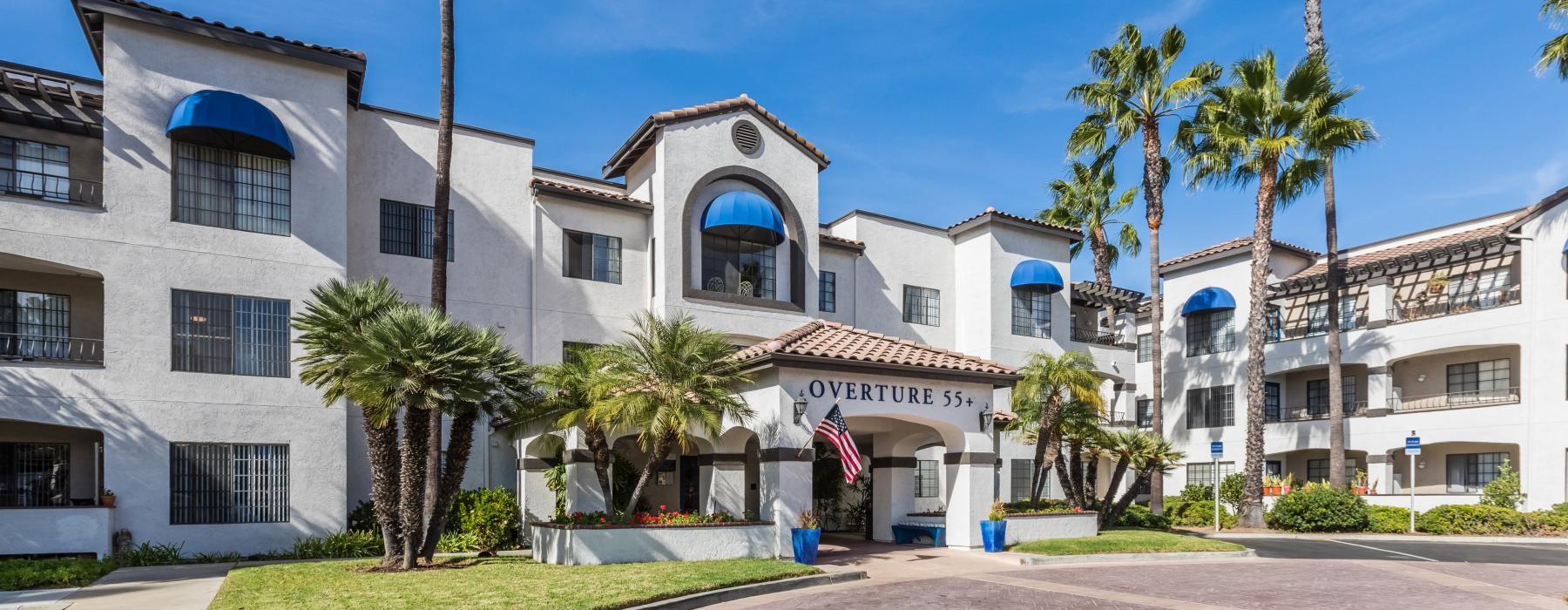 The exterior of Overture San Marcos over 55 apartments in San Marcos, CA, featuring a spanish style facade.
