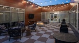 Roof top patio with checkered floor, string lights and seating 