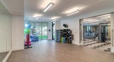 large well lit yoga room with mirrors and wood floors