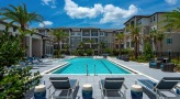 Large sparkling blue pool with lounge chairs 