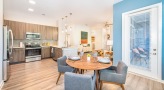Spacious and well lit kitchen with stainless steel appliances and dark accents 