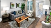 Spacious and well lit living room with wood floors and a large window