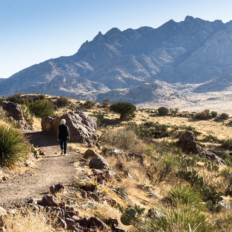 Albuquerque Woman walking along a hiking trail with the mountains in the background in New Mexico