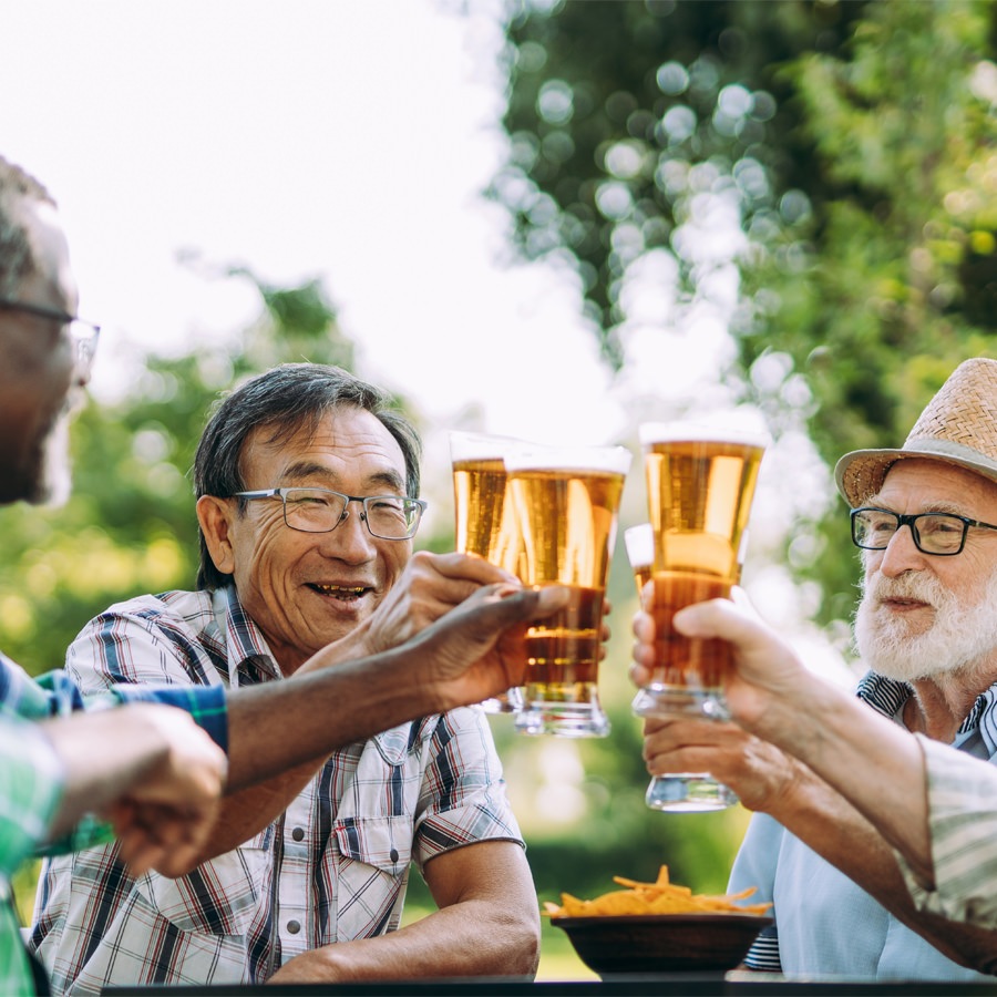 Birmingham Group of senior men drinking around a table outside.