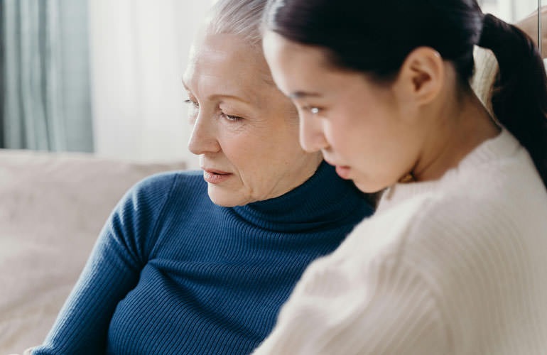 woman and her mother sitting on a couch