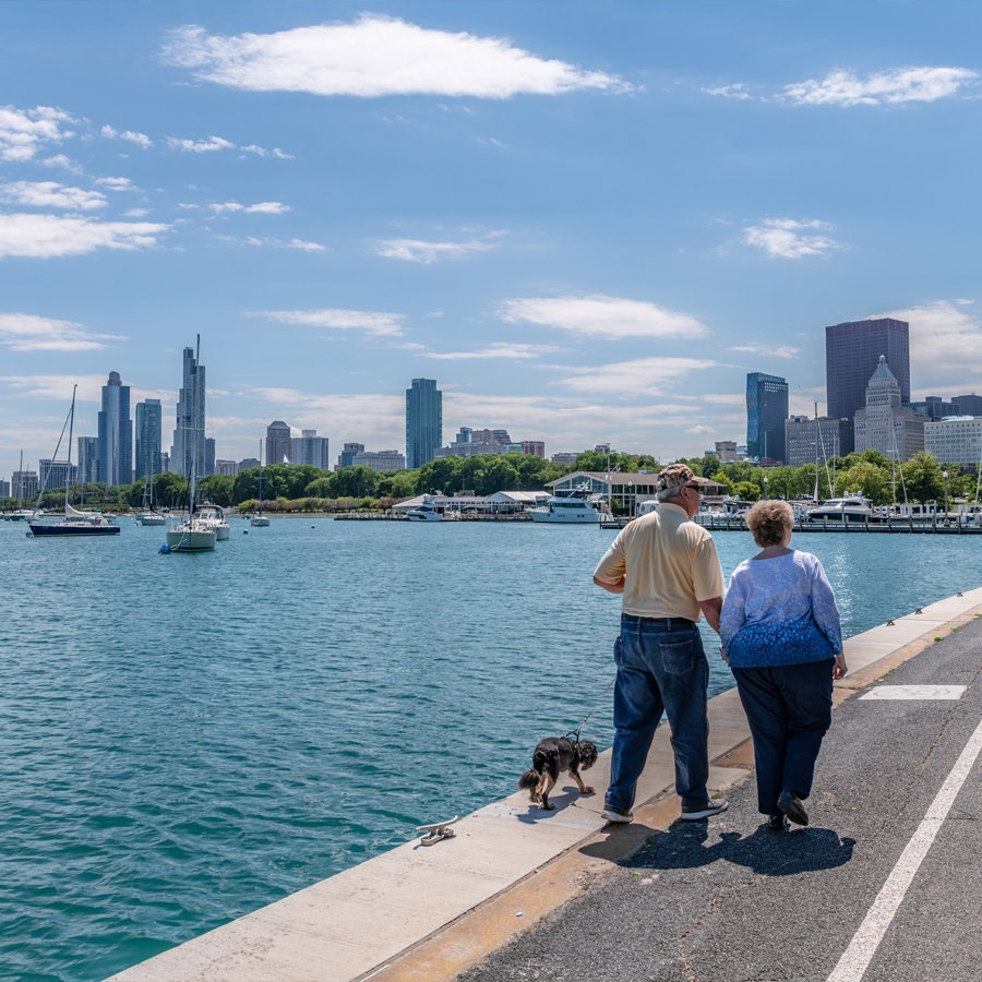 Chicago Senior couple walking along the river in Chicago with their pet dog.