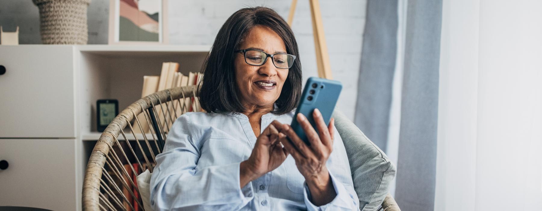 Someone using their phone at Overture Plano senior living apartments in Plano, TX, featuring modern decor.