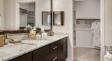bathroom with a double vanity and large mirror