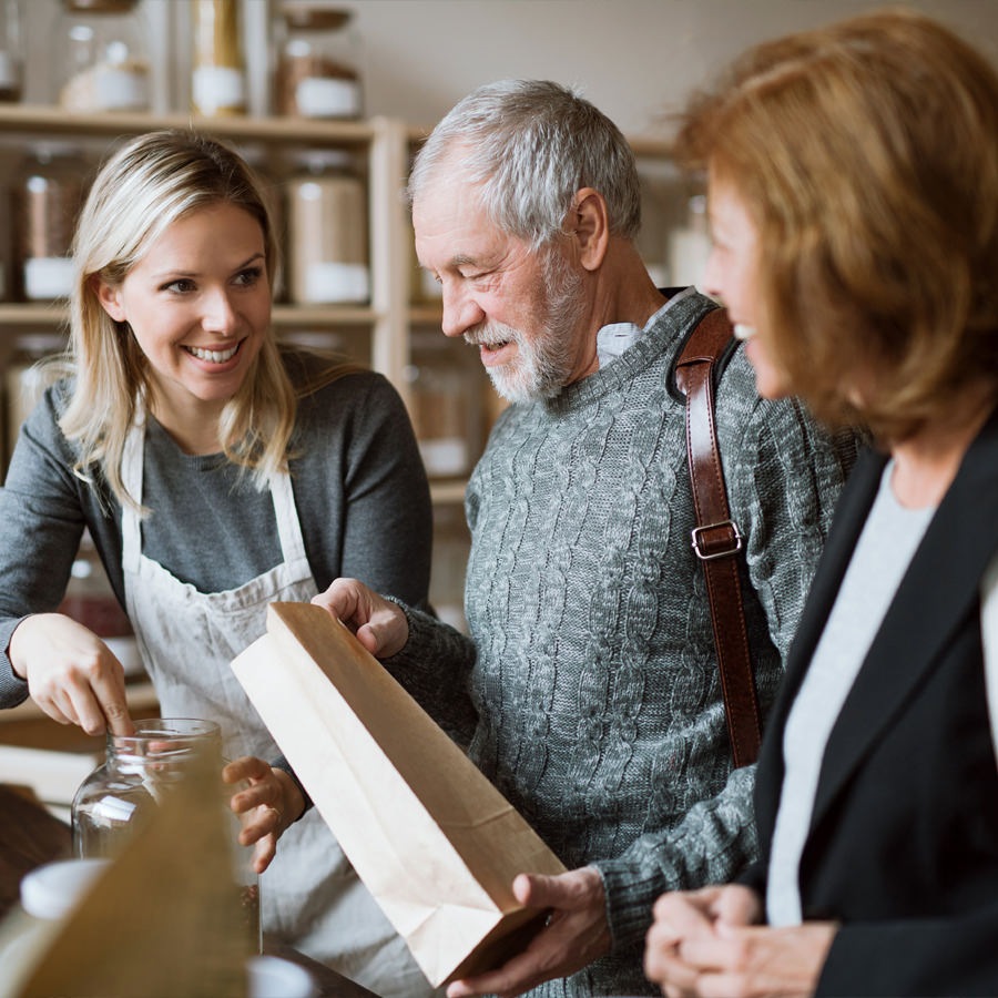 Dallas Fort Worth Senior couple talking with a retail worker in a shop.