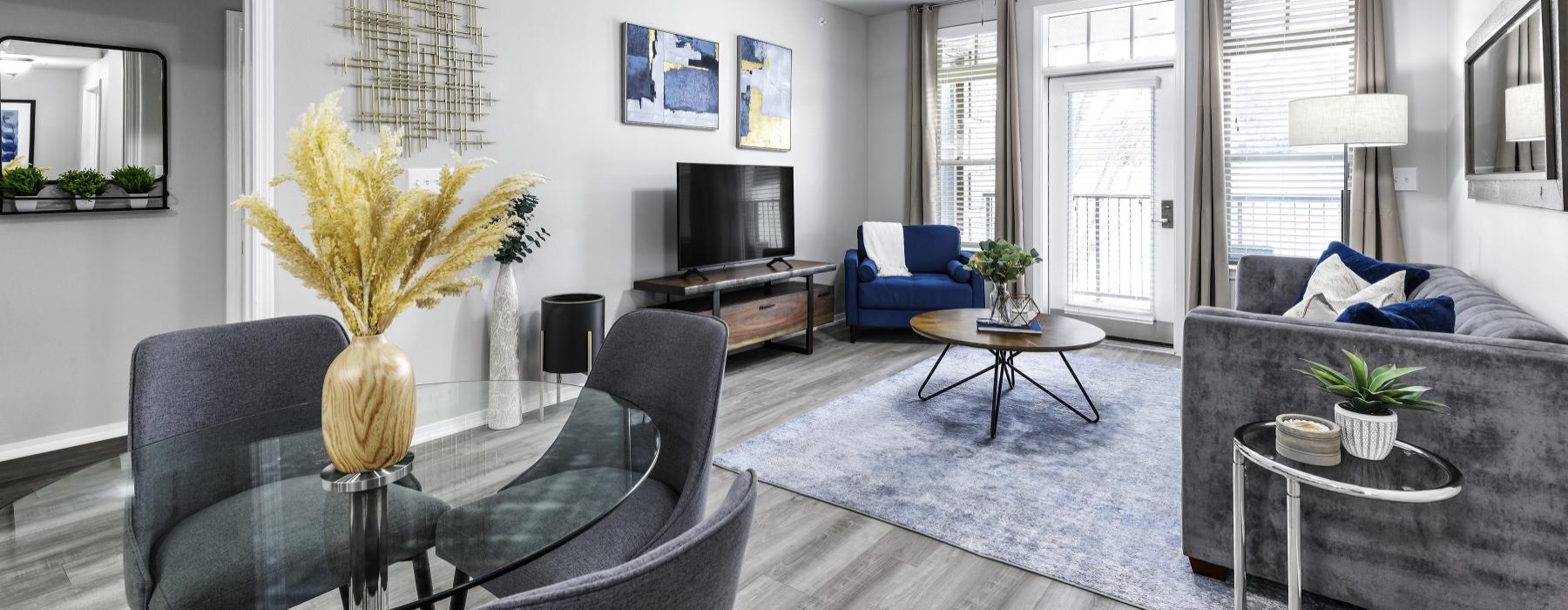  Model living room at Overture Ridgmar senior living apartments in Fort Worth, TX, featuring wood grain flooring and a TV.