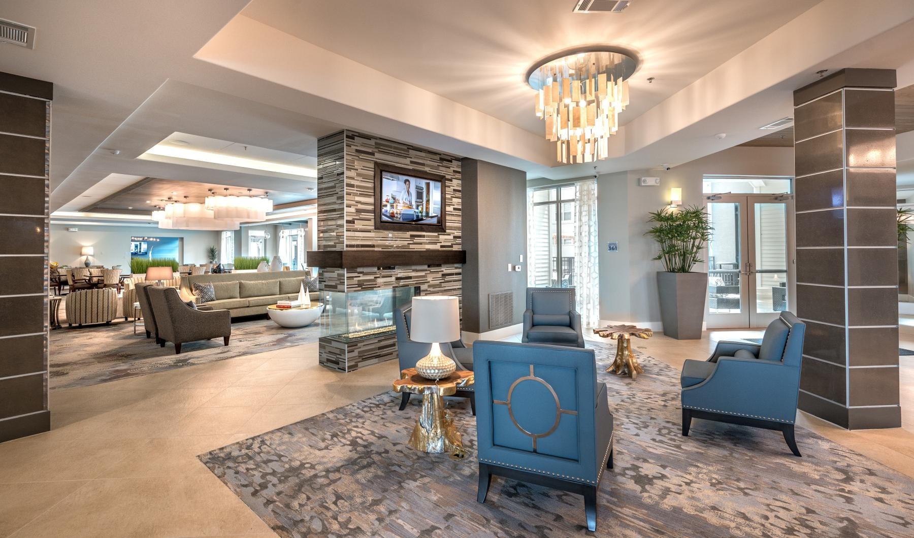 Resident lounge at Overture Plano senior living apartments in Plano, TX, featuring couches and a flat screen TV.