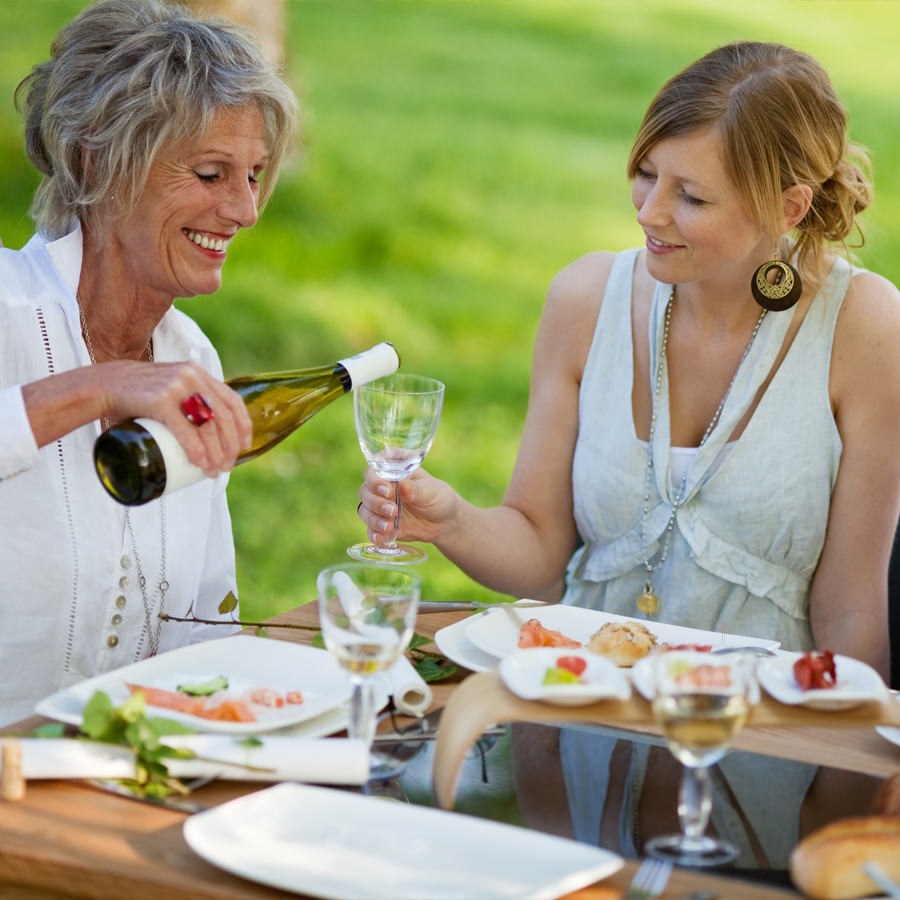 Greenville A group of ladies sit outside having dinner with wine and fish.