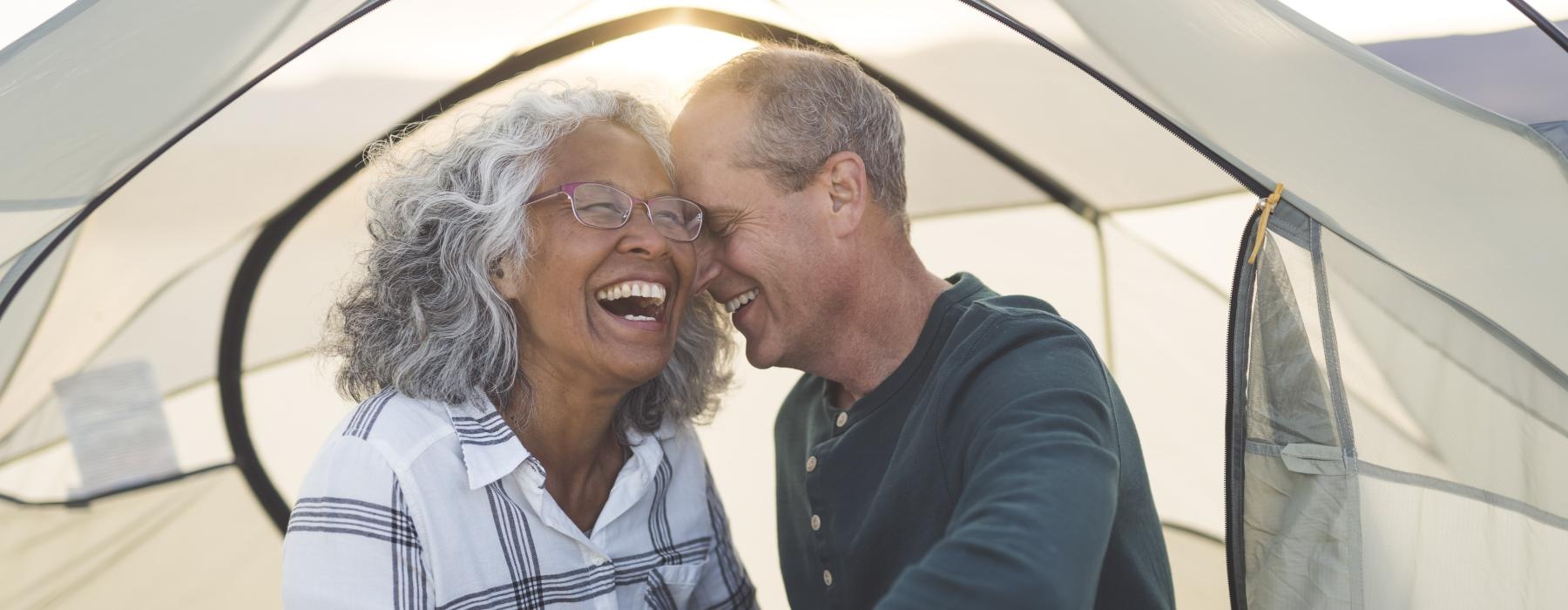 Two residents in a tent near Overture 9th + CO senior apartments in Denver, CO, featuring the sun through fabric.