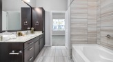 large bathroom with brown accents and closet space