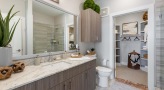 large bathroom with brown accents and closet space