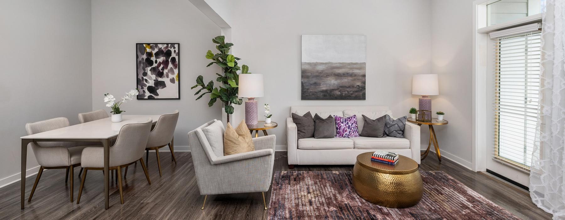 Model living room at Overture West Ashley senior living apartments in Charleston, SC, featuring wood grain floor paneling.