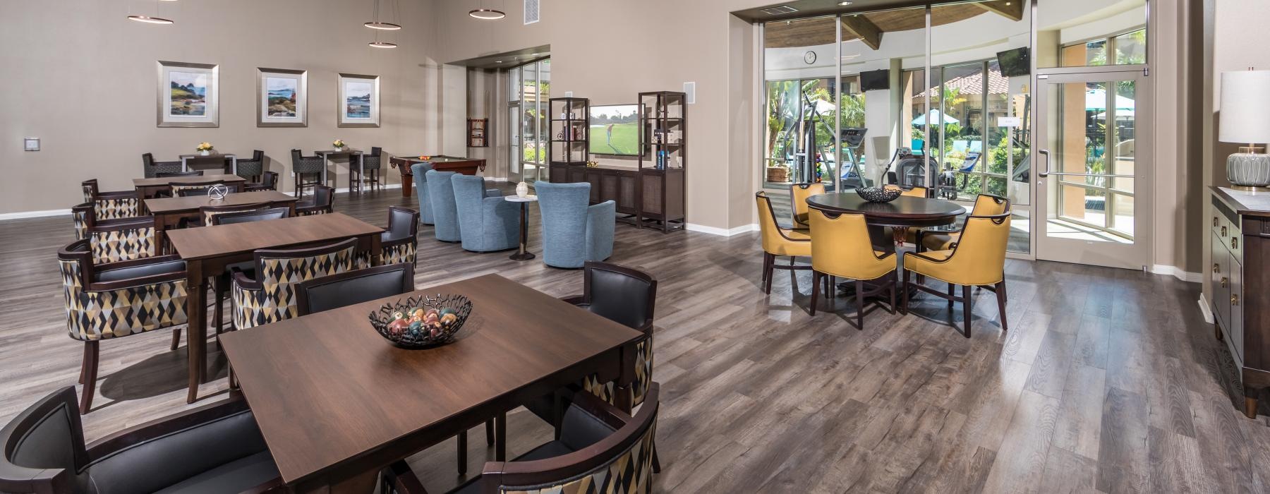 Dining lounge at Overture Rancho Santa Margarita over 55 apartments in Orange County, CA, featuring wood grain flooring.